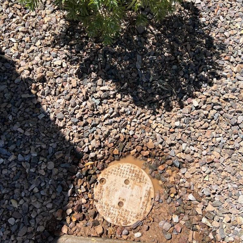 Pressure reducing valve box installed in gravel landscape