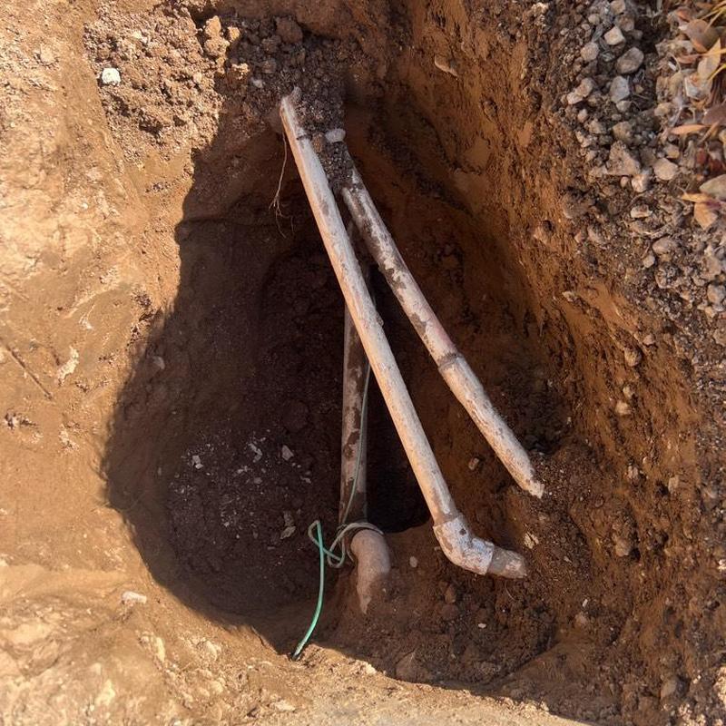 Main water service line excavation with irrigation lines above