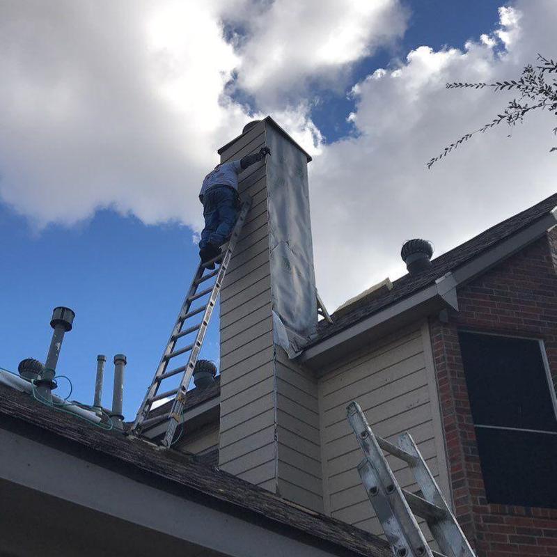 Chimney chase siding and trim installation on ladder Chimney chase siding and trim installation on ladder