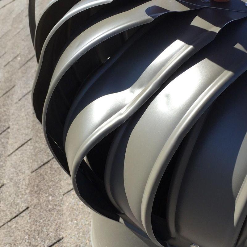 Turbine roof vent with dented metal blades on shingle roof