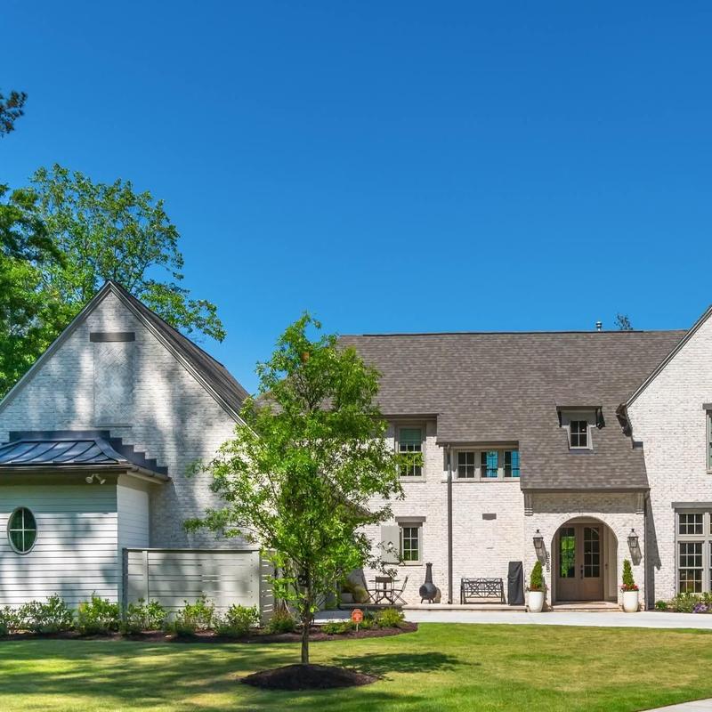 Asphalt roof on white brick house with tree