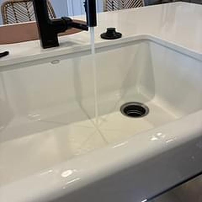 Kitchen sink drain with flowing water and black faucet