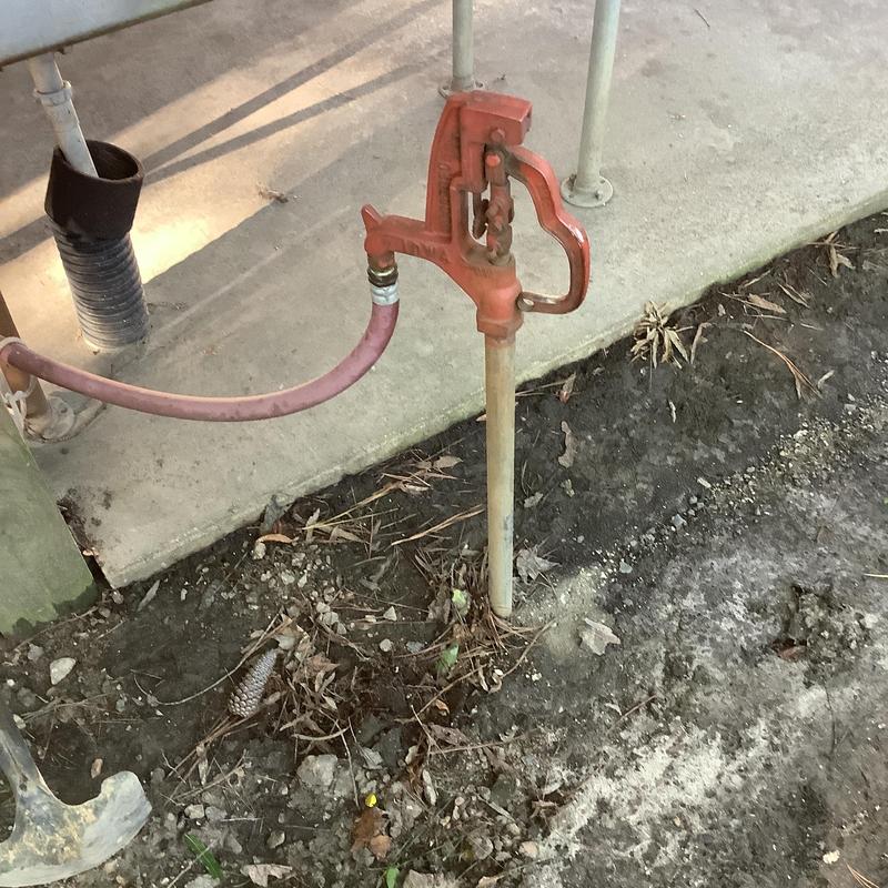 Yard hydrant with hose connected in soil area Yard hydrant with hose connected in soil area