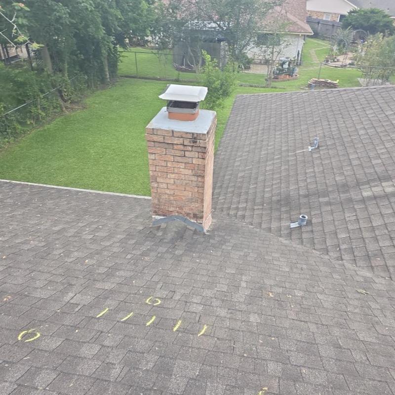 Roof shingles with hail damage markings near chimney