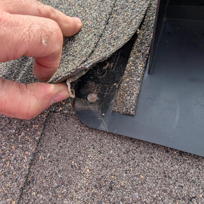 Bathroom vent flashing under roof shingles being inspected
