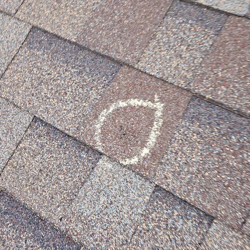 Shingle roof with hail damage marked for repair Shingle roof with hail damage marked for repair