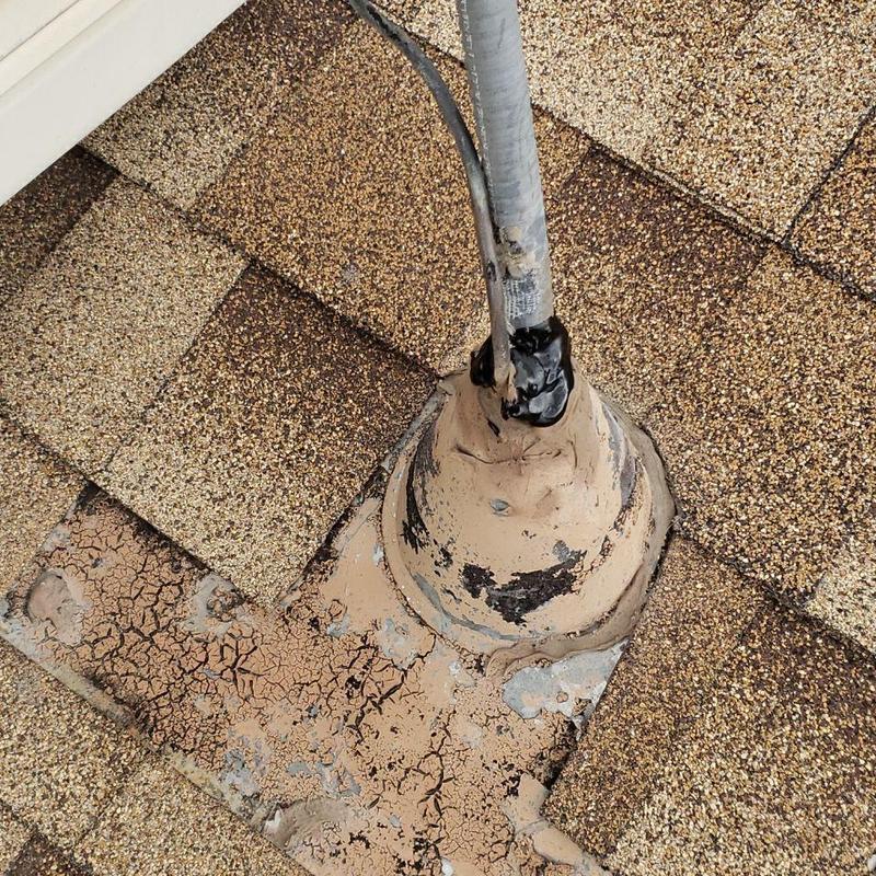 Shingle roof pipe jack with cracked sealant and cable Shingle roof pipe jack with cracked sealant and cable