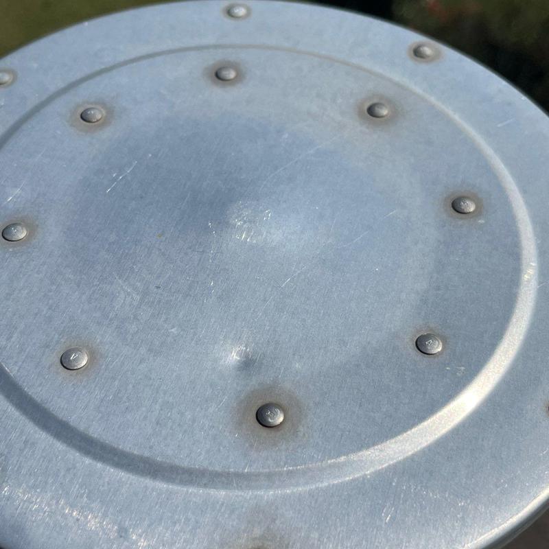 Metal roof vent cap with hail damage dents