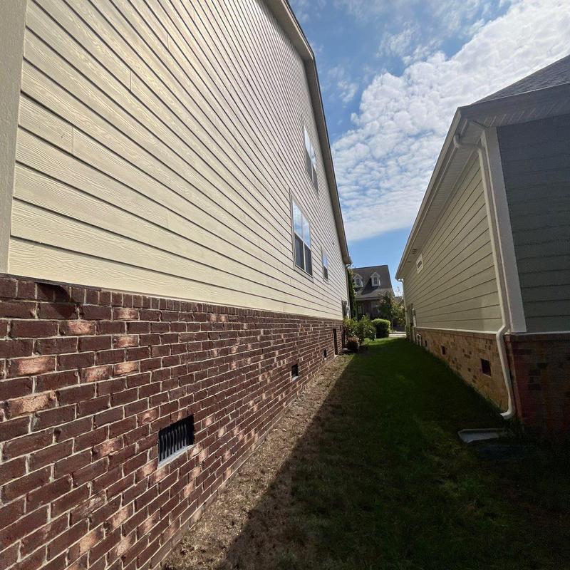 Home ventilation vents on brick siding between houses