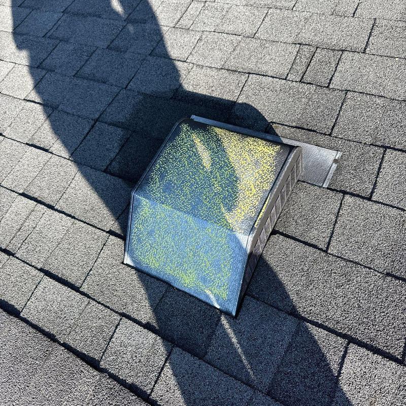 Roof vent with visible hail damage on shingles and flashing