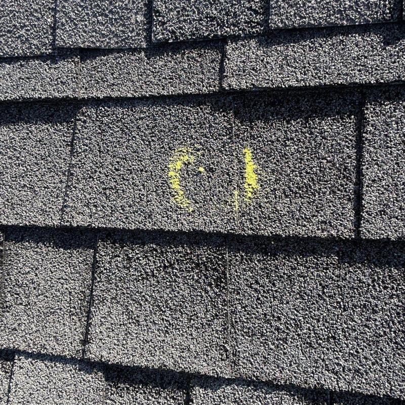 Roof shingles with hail damage marked in yellow