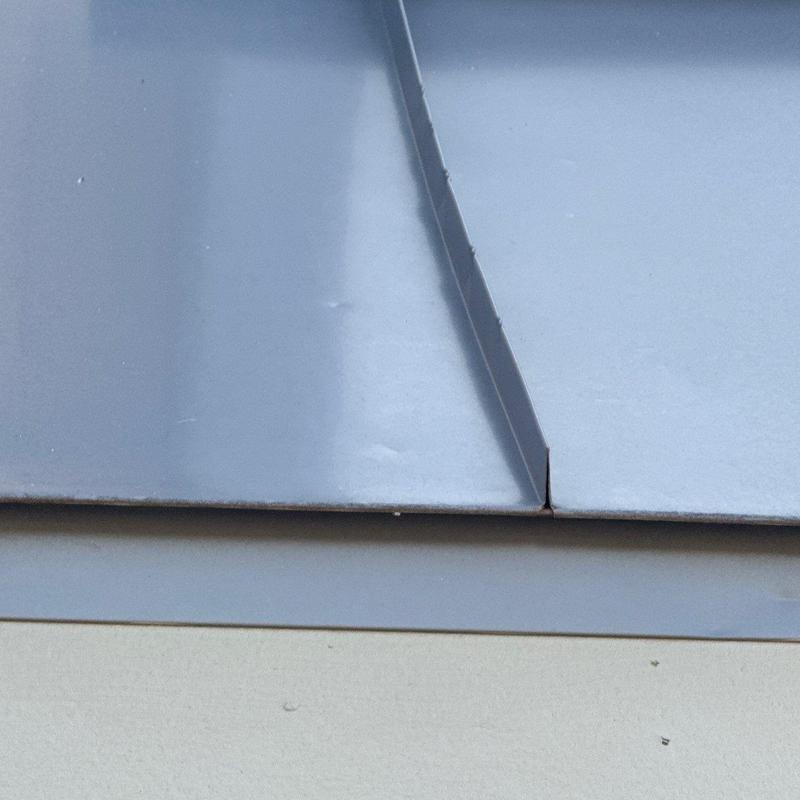 Metal flashing with hail damage dents close-up