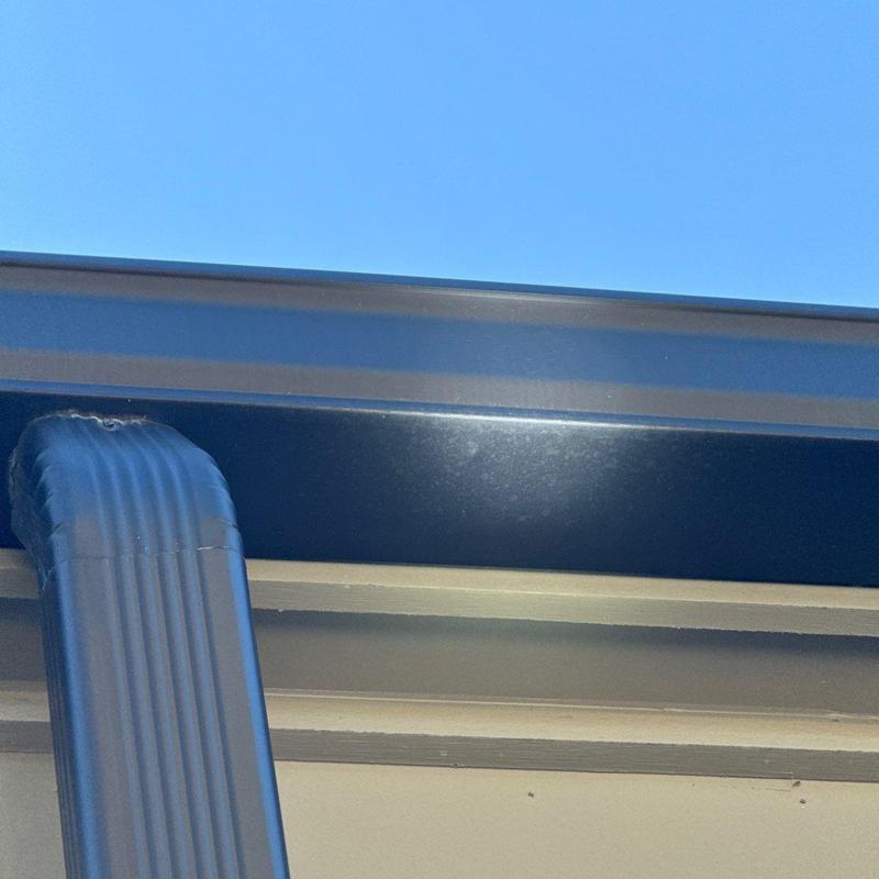 Metal gutter and downspout with roof edge
