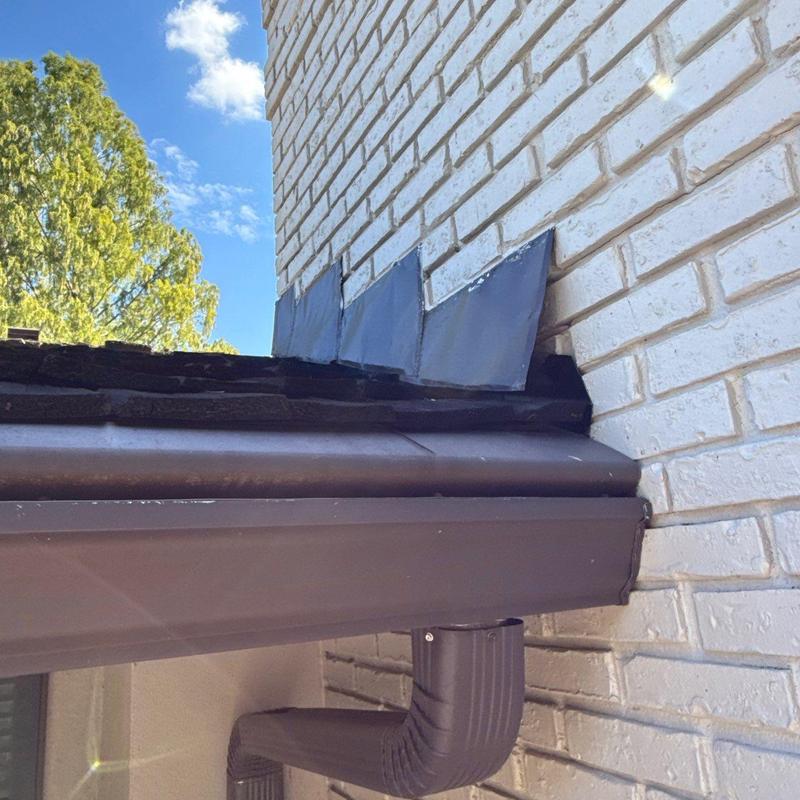 Roof flashing and gutter system near brick wall