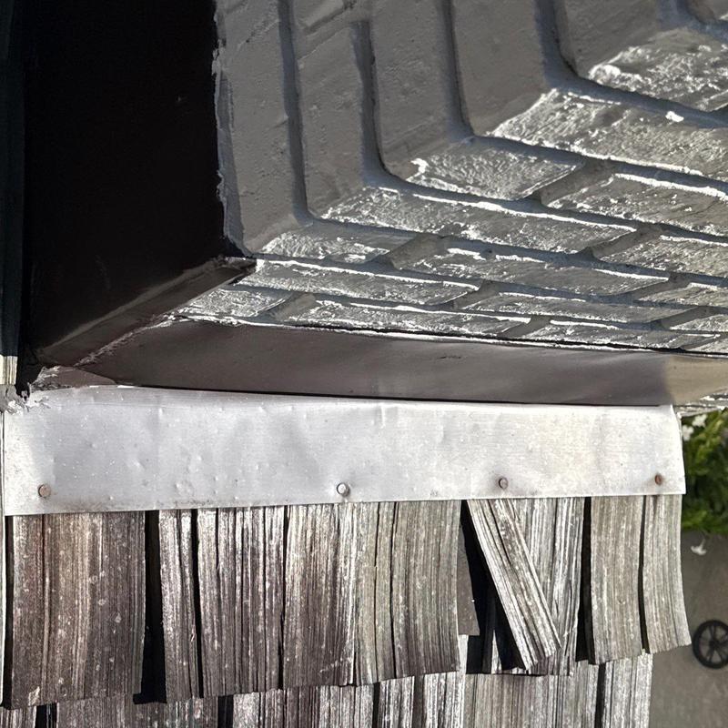 Metal flashing on weathered roof shingles close-up
