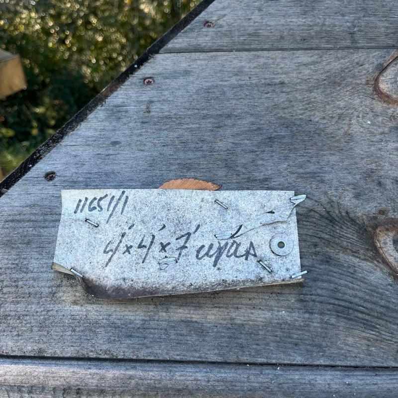 Roof decking with nail and handwritten measurement tag