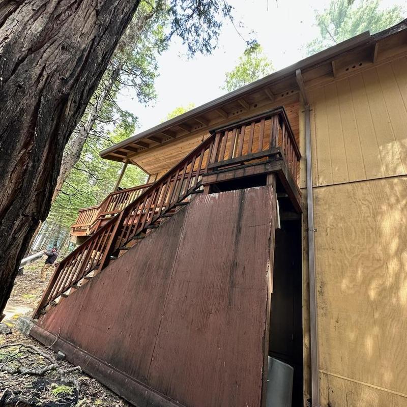 Seamless steel gutters with leaf blaster guards on cabin