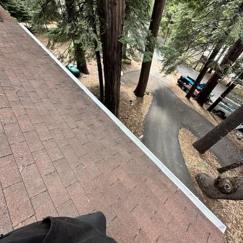 Steel seamless gutters with leaf blaster guards on roof edge