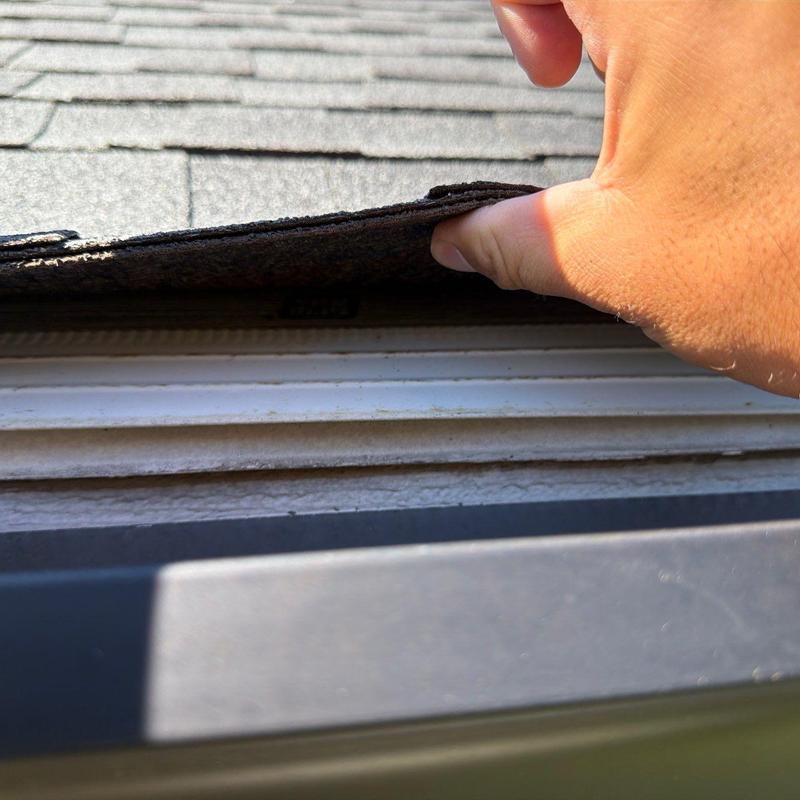 Asphalt shingle lifting near roof edge inspection