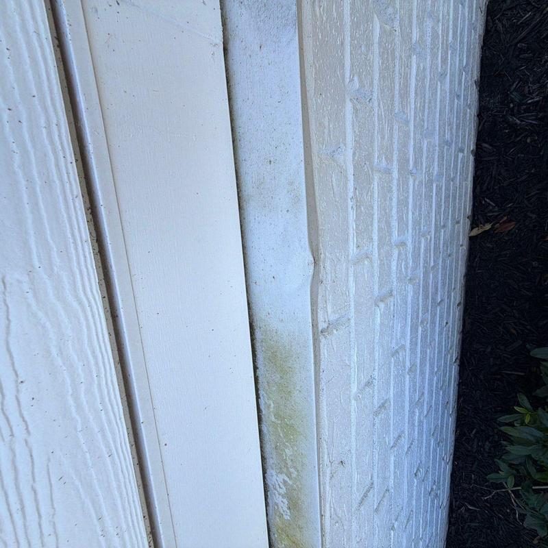 Vinyl siding panel warping and discoloration near brick wall