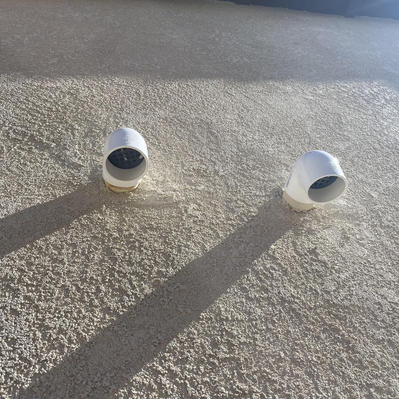 2-inch PVC exhaust pipe outlets on stucco wall