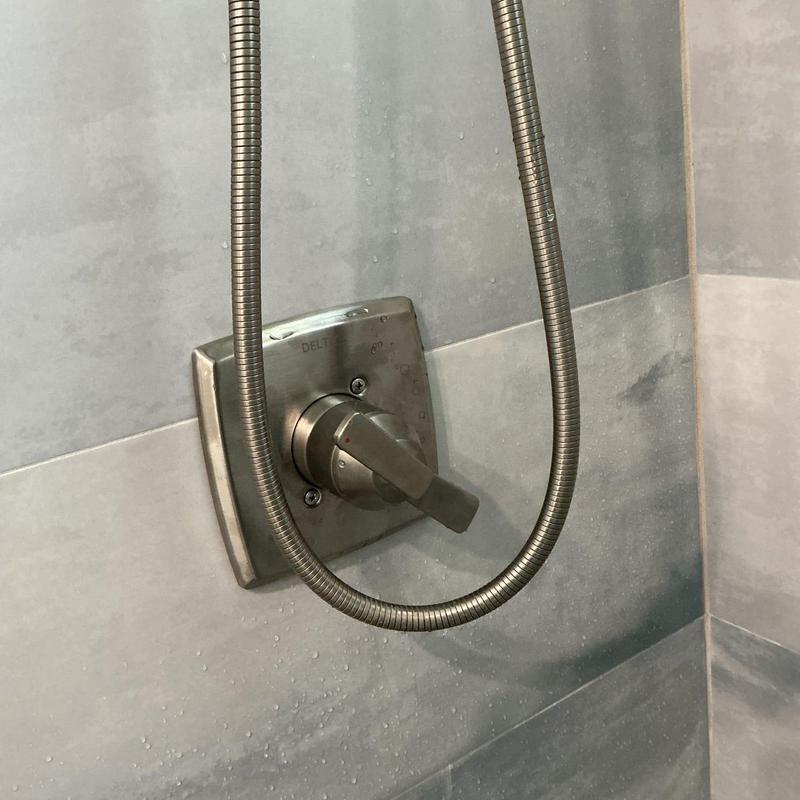 Delta shower valve trim and hose in tiled shower