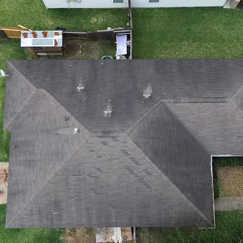 Asphalt shingle roof with visible wear and discoloration