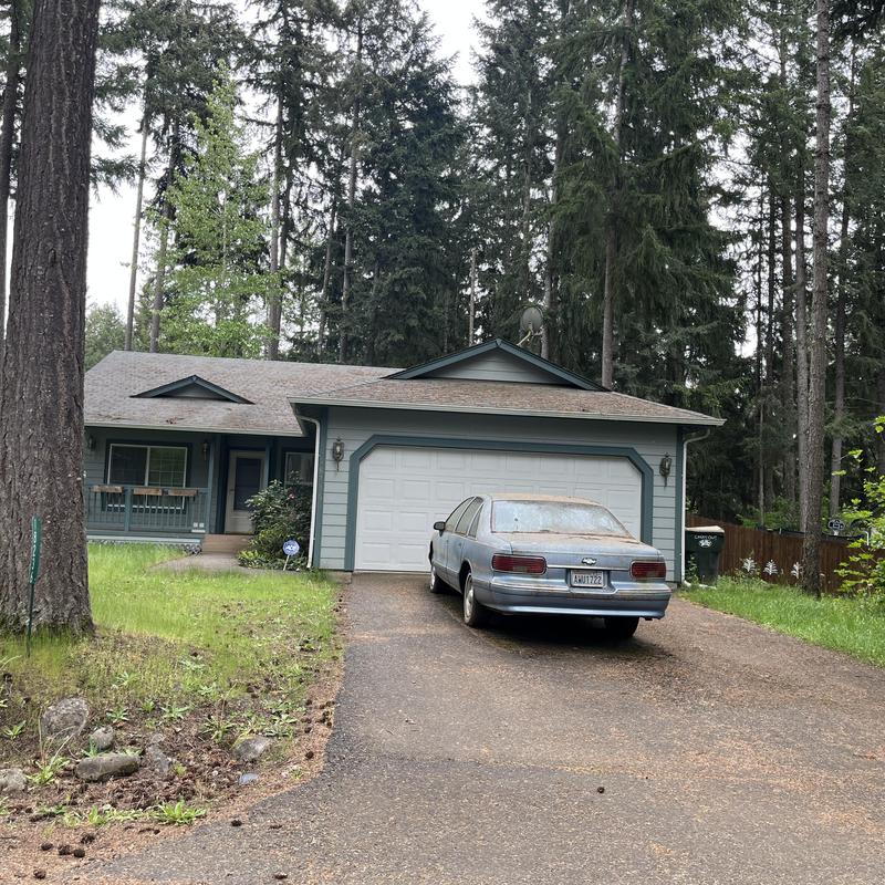Asphalt shingle roof on suburban house with parked car