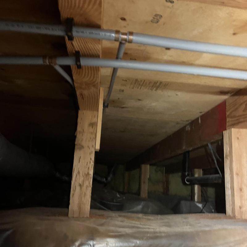 Polybutylene pipe secured in crawlspace joists