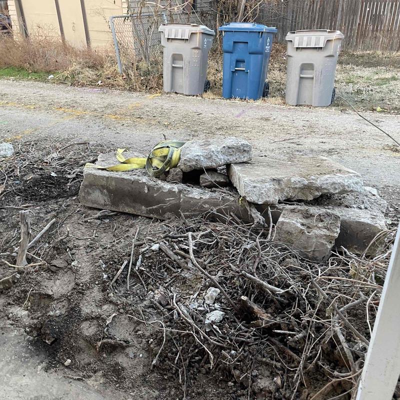 Main sewer line excavation with broken concrete slabs