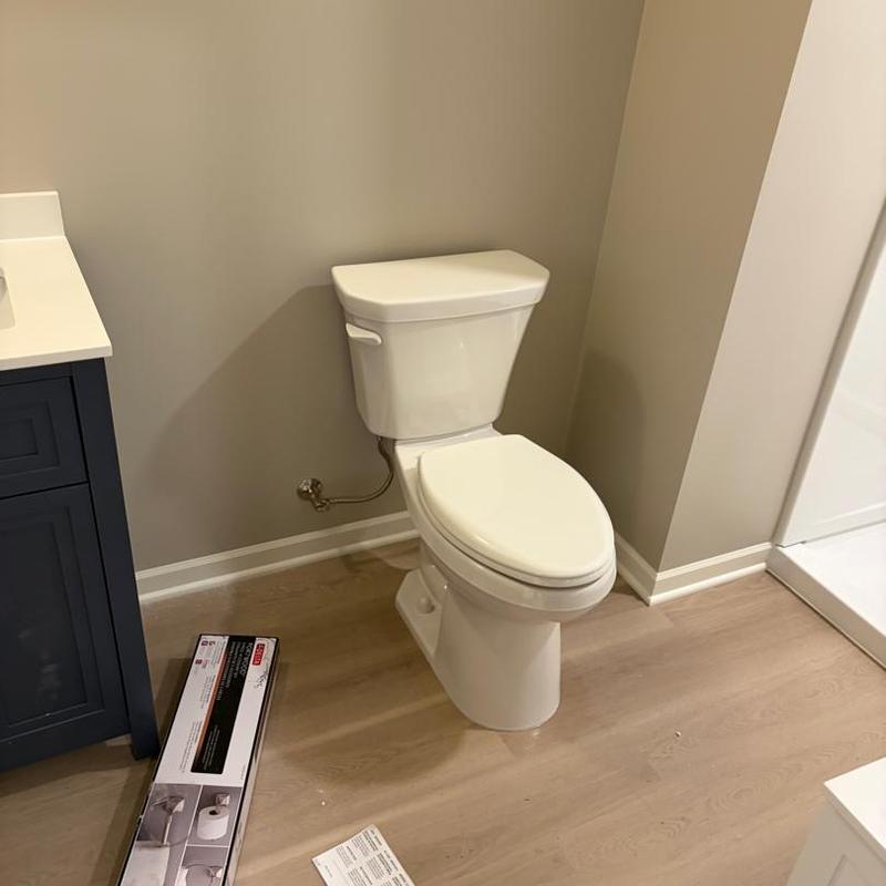 Toilet installation in bathroom remodel with wood flooring