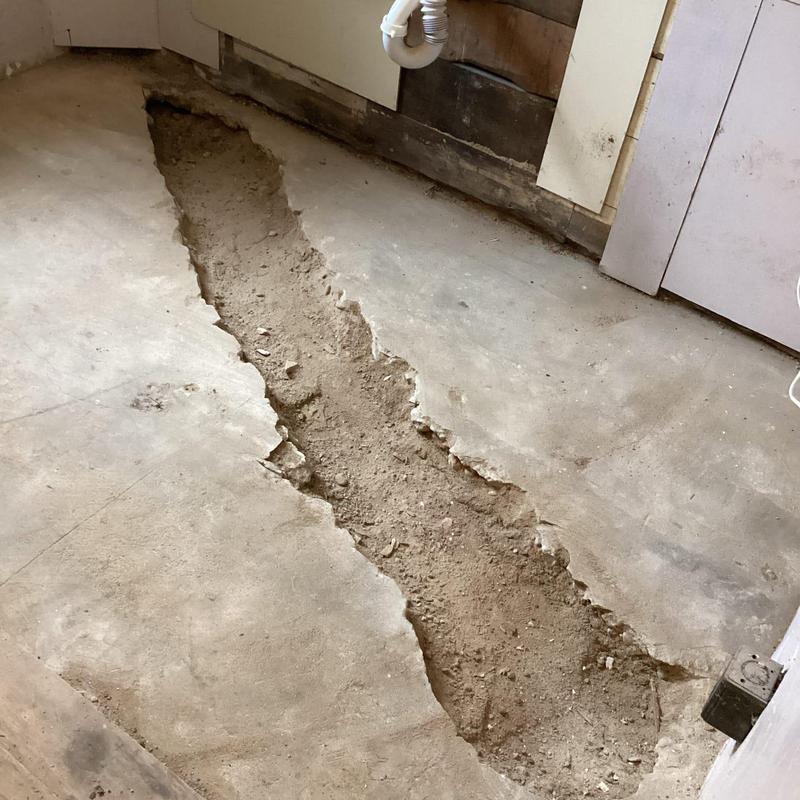 Cast iron branch line trench saw cut in concrete floor