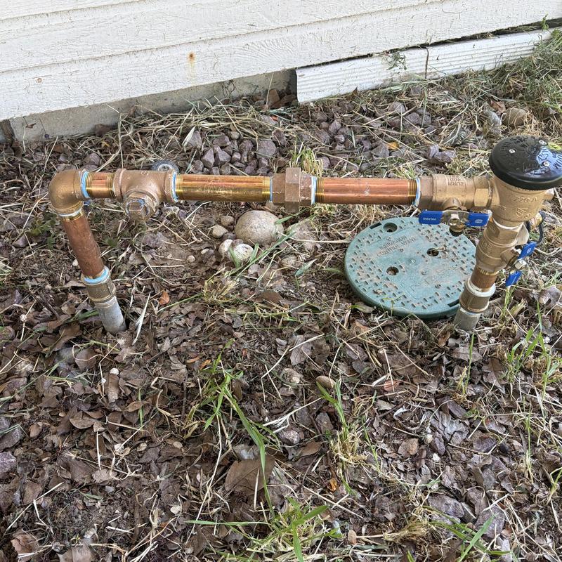 Backflow preventer installation with copper piping outdoors