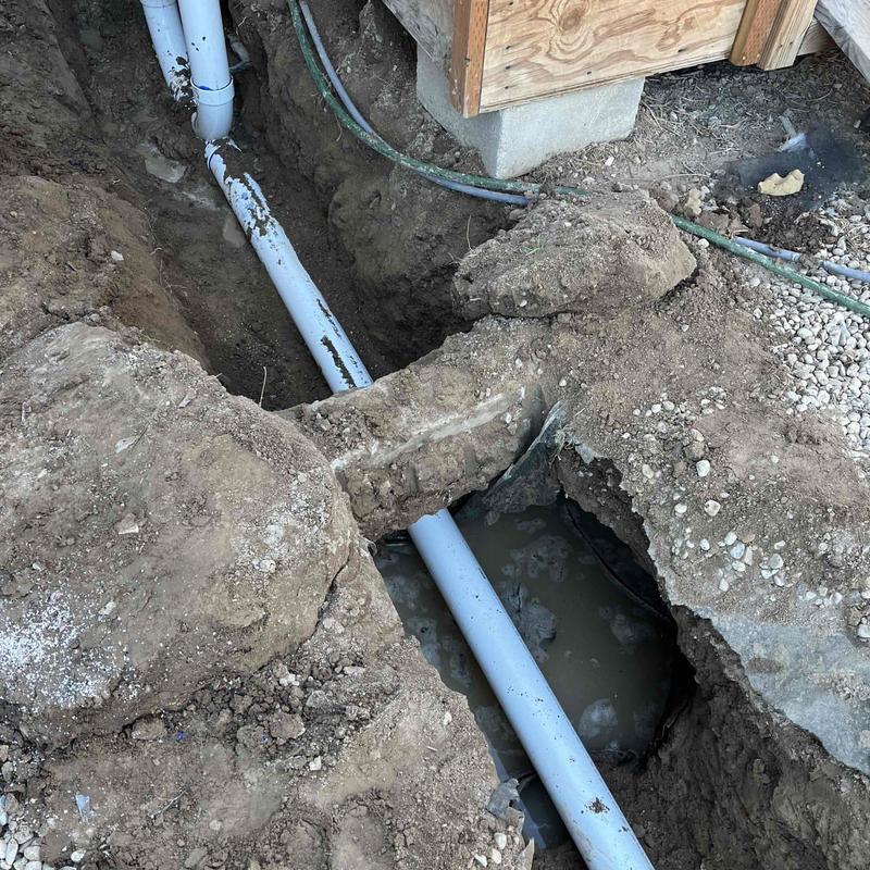 Cesspool pipe installation in dirt trench with water