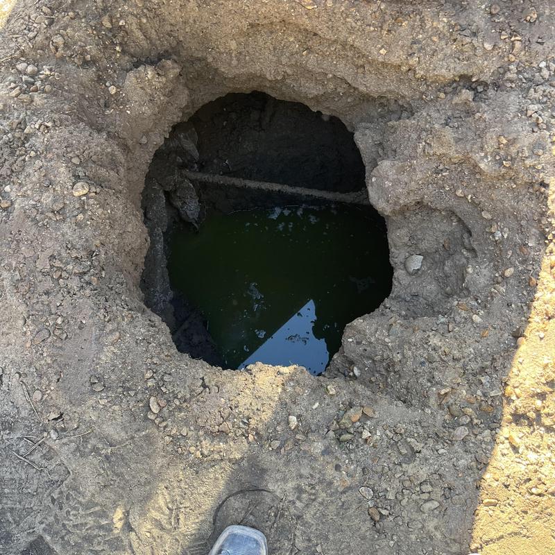 Cesspool with standing liquid and debris inside pit