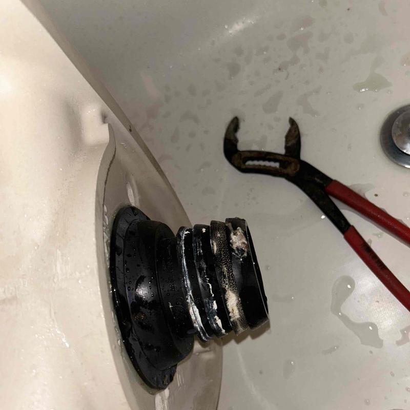 Toilet tank to bowl gasket with plumbing tool nearby