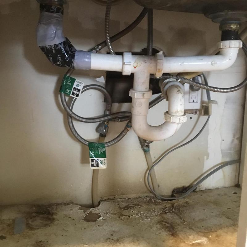 Kitchen sink drain pipes with water damage signs