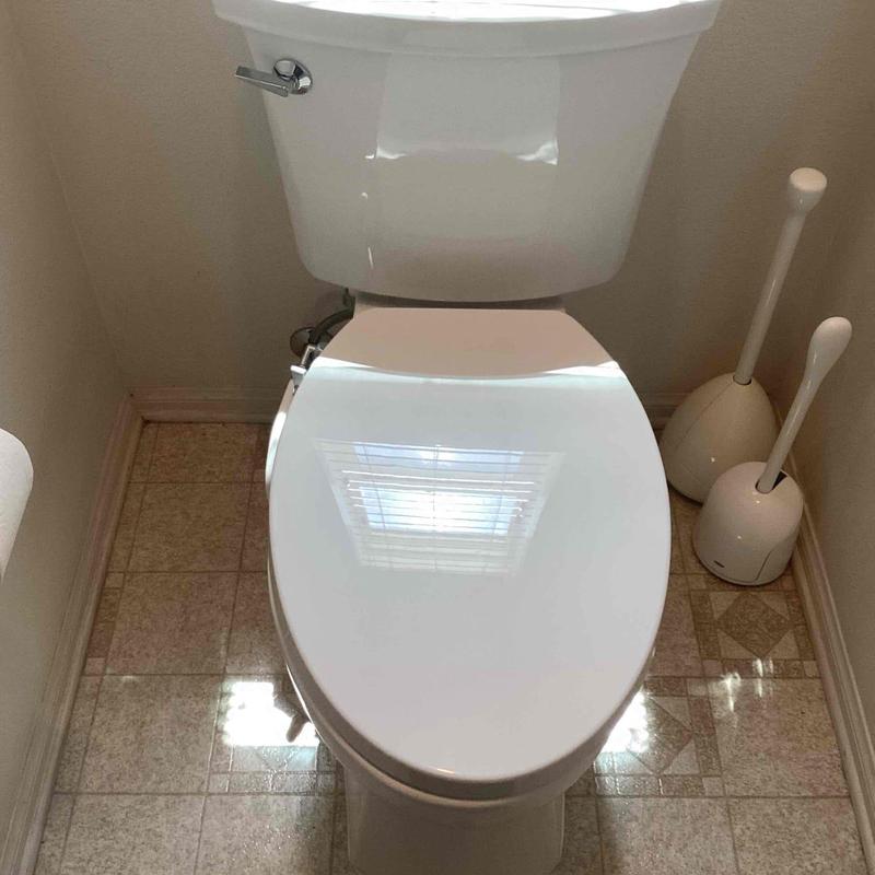 Toilet with new wax ring seal installed in bathroom