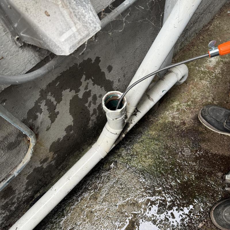 Drain line snaking at clogged residential clean-out pipe Drain line snaking at clogged residential clean-out pipe