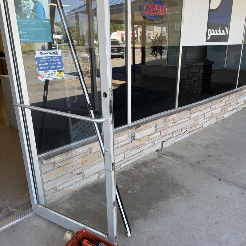 Glass door frame with removed strip at Goodwill entrance Glass door frame with removed strip at Goodwill entrance