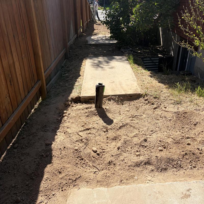 Sewer main pipe installed and backfilled near walkway