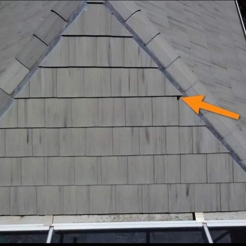 Roof shingles with visible nail and orange arrow indicator