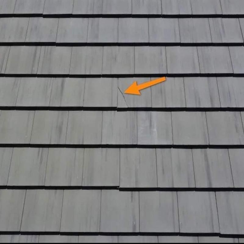 Concrete roof tile crack marked with orange arrow