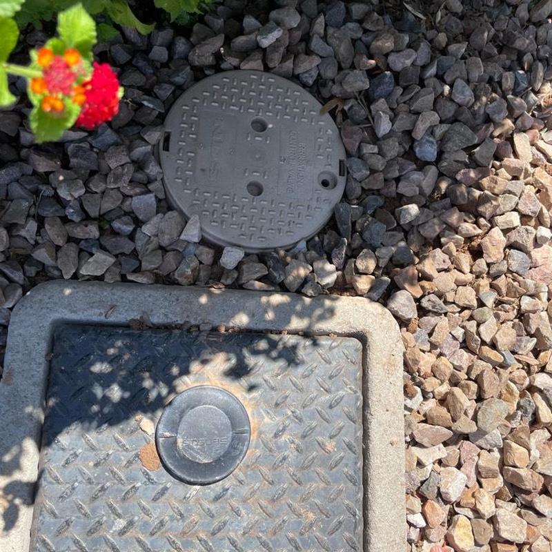 1 inch PRV access box set in ground with rocks