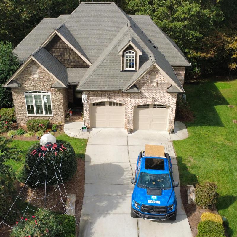 Asphalt shingle roof with Escalade Roofing truck in driveway