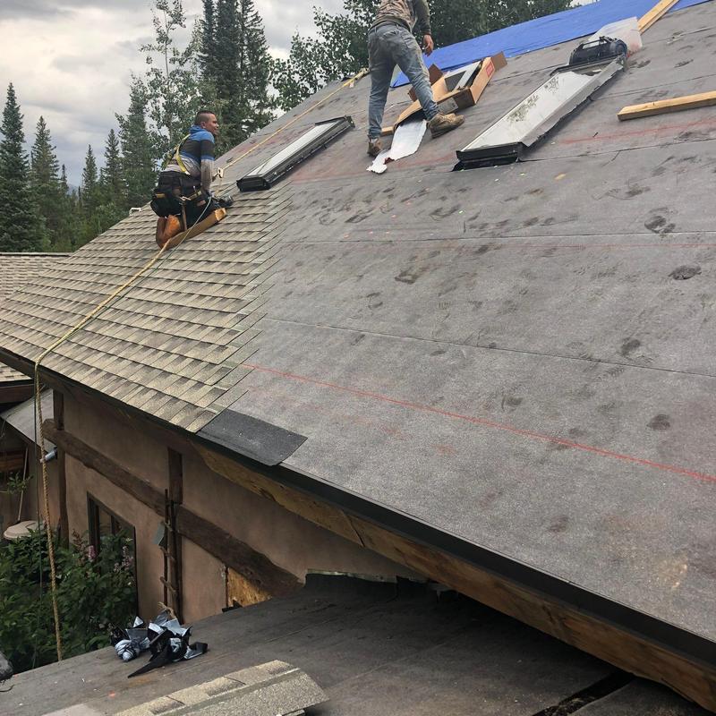 Asphalt shingle roof installation with skylights on slope
