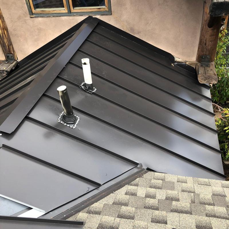 Metal standing seam roof with vent pipes