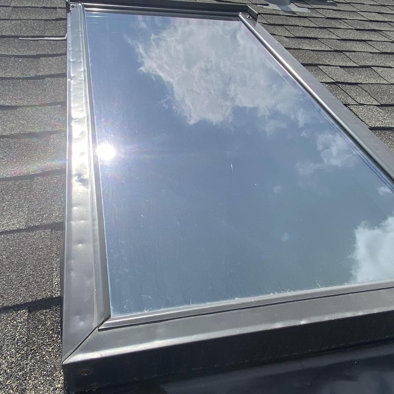 Skylight window with metal flashing on shingle roof