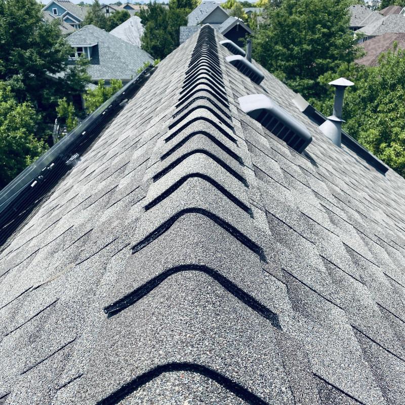Asphalt shingle roof ridge with new shingles installed