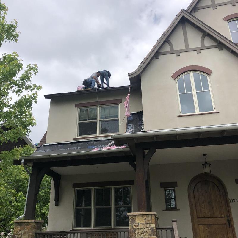 Asphalt roof shingles installation on two-story house
